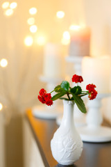 Flowers in a vase against a backdrop of candles and lights. Postcard. Space for text. 8 March