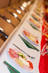 Decorated catering banquet table with appetizers with ham, salami and eggs. Selective focus. Vertical photo