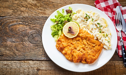 Schnitzel with side dish on rustic table