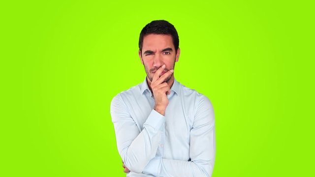 Suspicious young man against green background