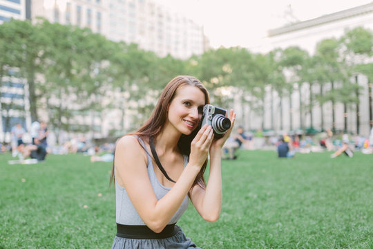 Young American Girl Using a Vintage Camera in Briant Park . Manhattan New York City US