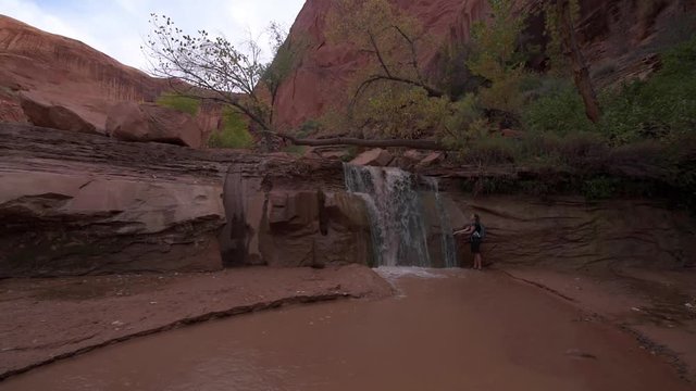 Hiker cooling off near Waterfall on a lower section of the Coyote Gulch