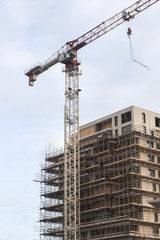 scaffolding on building site of new apartment building and crane