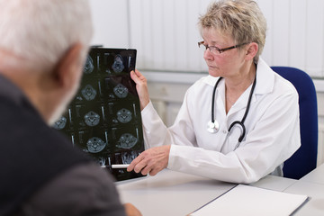 Ärztin in Beratung mit Patient und Röntgenbild