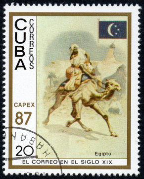 UKRAINE - CIRCA 2017: A stamp printed in Cuba, shows a man with a cargo moved on a camel Egypt, the series The mail in the nineteenth century, circa 1987