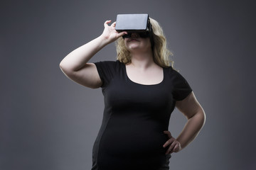 Young plus size woman uses a virtual reality glasses