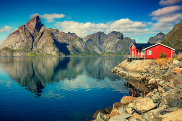 Beau village de pêcheurs sur le fjord. Belle nature avec ciel bleu, reflet dans l& 39 eau, plage rocheuse et maison de pêche (rorby). Lofoten, Reine, Norvège