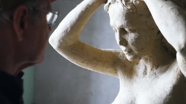 Scultor modeling woman sculpture in modeling clay