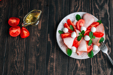 salad with tomatoes, meats, herbs and mozzarella cheese