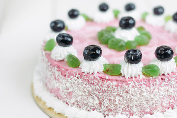 Сake with blueberries on a white wooden table