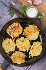 Potato Pancakes. Vegetable fritters. Latkes in frying pan. View from above, top studio shot