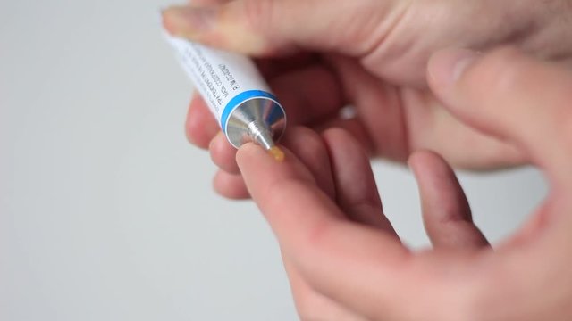 Squeezing out an ointment from a tube