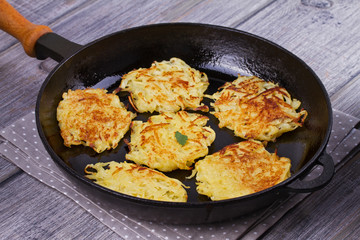 Potato Pancakes. Vegetable fritters. Latkes in frying pan.