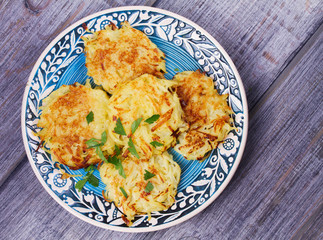 Potato Pancakes With Yogurt Sauce. Vegetable fritters. Latkes on blue plate. View from above, top studio shot