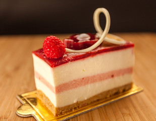 Raspberry cheesecake with raspberry glaze and a white chocolate detail