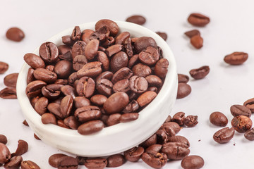 Coffee beans in a bowl on a white background