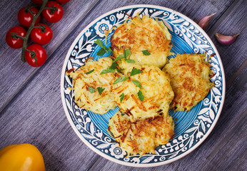Potato Pancakes With Yogurt Sauce. Vegetable fritters. Latkes on blue plate. View from above, top studio shot