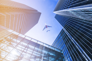 Airplane flying over business skyscrapers.