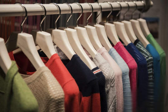 Color sweaters on a rack in a boutique store