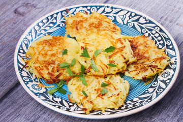 Potato Pancakes With Yogurt Sauce. Vegetable fritters. Latkes on blue plate