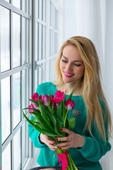 Young cute girl with bunch of spring flowers smiling, 8 march, international womens holiday.