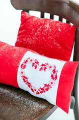 красные подушки с сердцем вышитым крестиком.зимний декор красной фотосессии