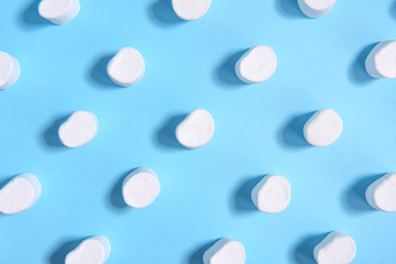 White sweeties marshmallows over blue table background.
