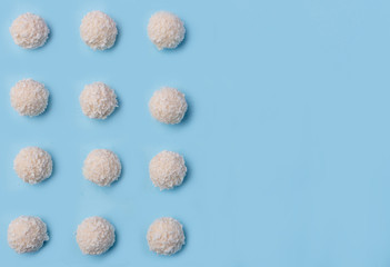 Coconut sweeties candy over blue table background.