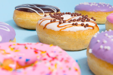 Colorful sweeties donuts over blue table background.