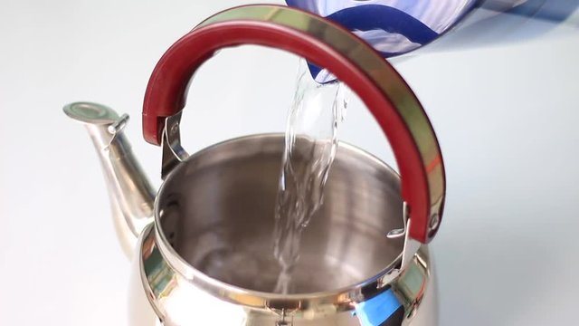 Pouring a pot with water from a water-filter