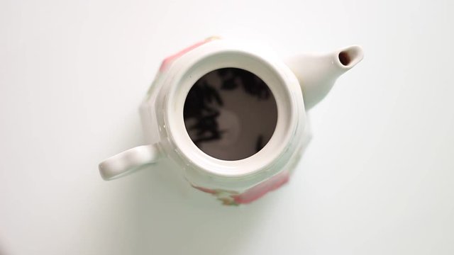 Putting a tea into the white teapot