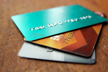 Stack of credit cards on a wooden background with selective focus, close up view.