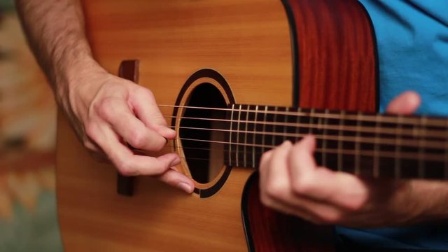 Playing an acoustic guitar with picker