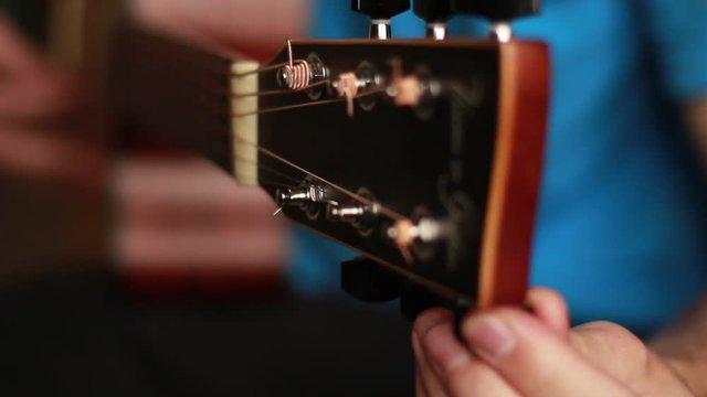 Hand adjusting an acoustic guitar