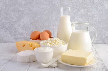 Papier Peint photo Produits laitiers Produits laitiers frais. Lait, fromage, brie, camembert, beurre, yaourt, fromage cottage et œufs sur table en bois.