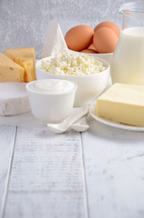 Fresh dairy products. Milk, cheese, brie, Camembert, butter, yogurt, cottage cheese and eggs on wooden table.