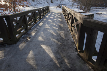 Ornamental wooden bridge in the winter evening. Nice texture with shadows.