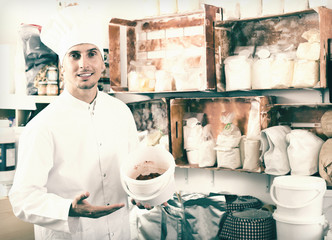 Happy male cook standing in pantry room