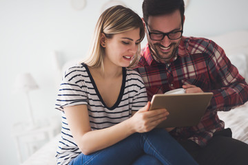 Couple surfing the web on tablet and smiling