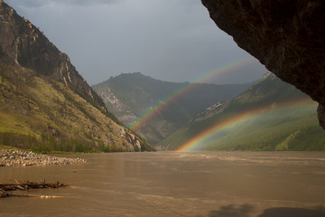 Double rainbow above the muddy river in the mountains. The River Indigirka. The Republic Of Sakha....