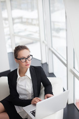 Young woman working at lap top in the office.