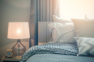 classic lamp style with alarm clock on table side in cozy bedroom