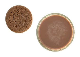 Top view of a glass of chocolate milk with a cookie to the side isolated on a white background.