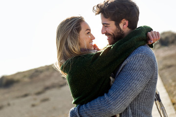Happy young couple enjoying the day in a cold winter on the beach.