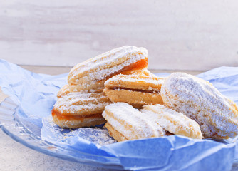 Shortbread butter cookies with apricot jam  on   glass plate with free text space. Selective focus.
