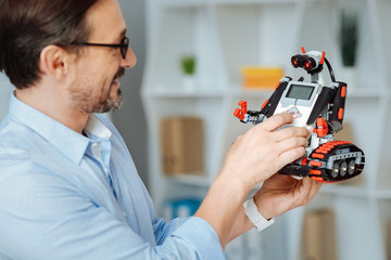 Joyful engineer testing robot