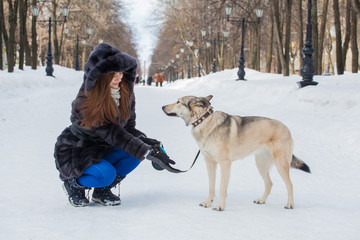 young beautiful girl on a walk in the winter with her pet dog