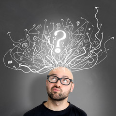Young attractive perplexed geek man with brainstormaing arrow over the head