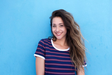 beautiful young woman smiling against blue background
