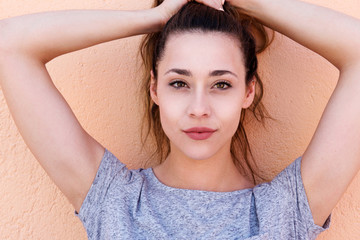 young beautiful woman holding hair above head